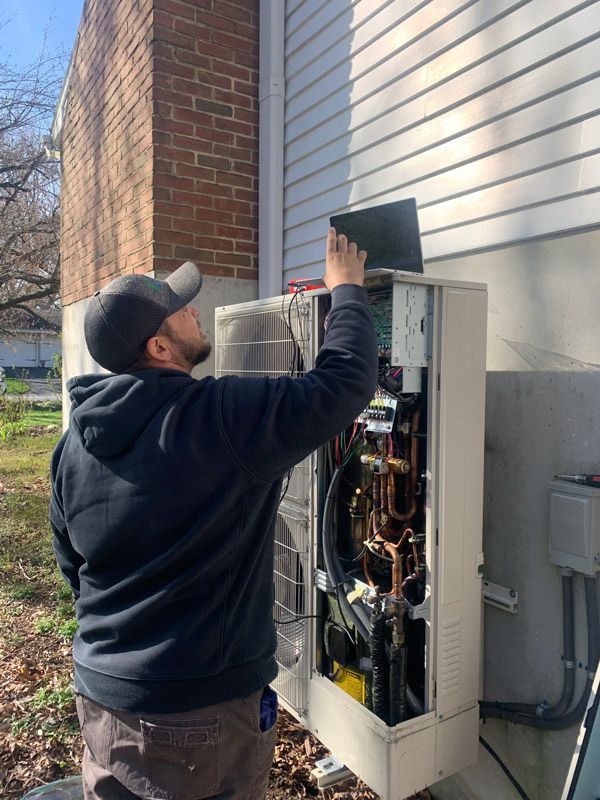 jason of Legacy comfort systems working on an AC unit